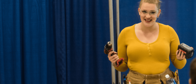 A woman presenting and demonstrating different tools in front of an audience.